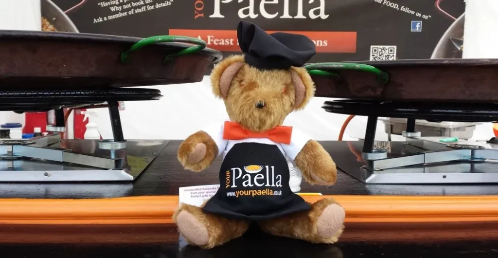 The Your Paella Teddy Bear sitting on the paella cart